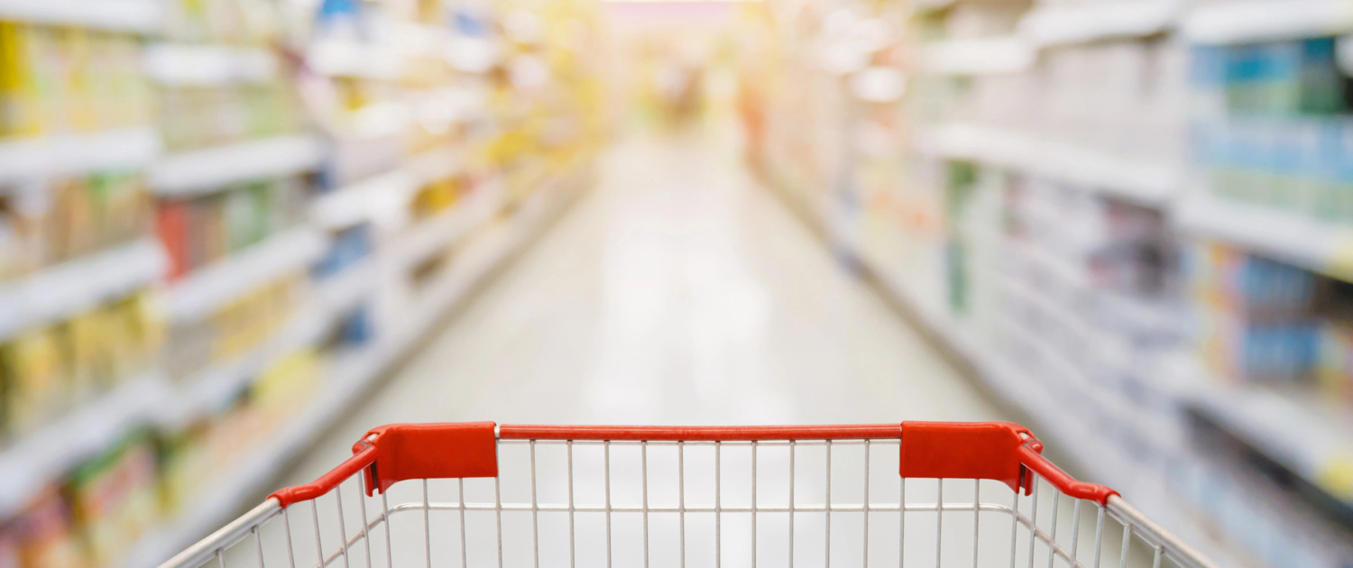 Supermarket aisle with red shopping cart